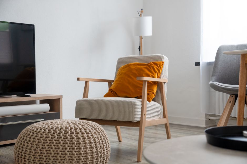 Modern living room interior featuring a comfy armchair, plush pillow, and sleek furniture.