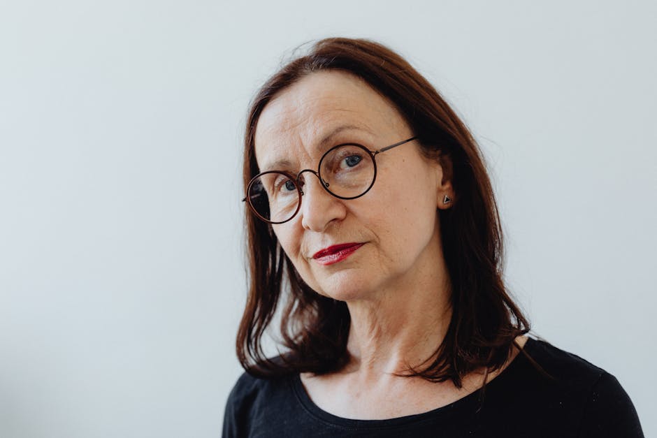 Captivating portrait of an older woman with eyeglasses and a thoughtful expression.
