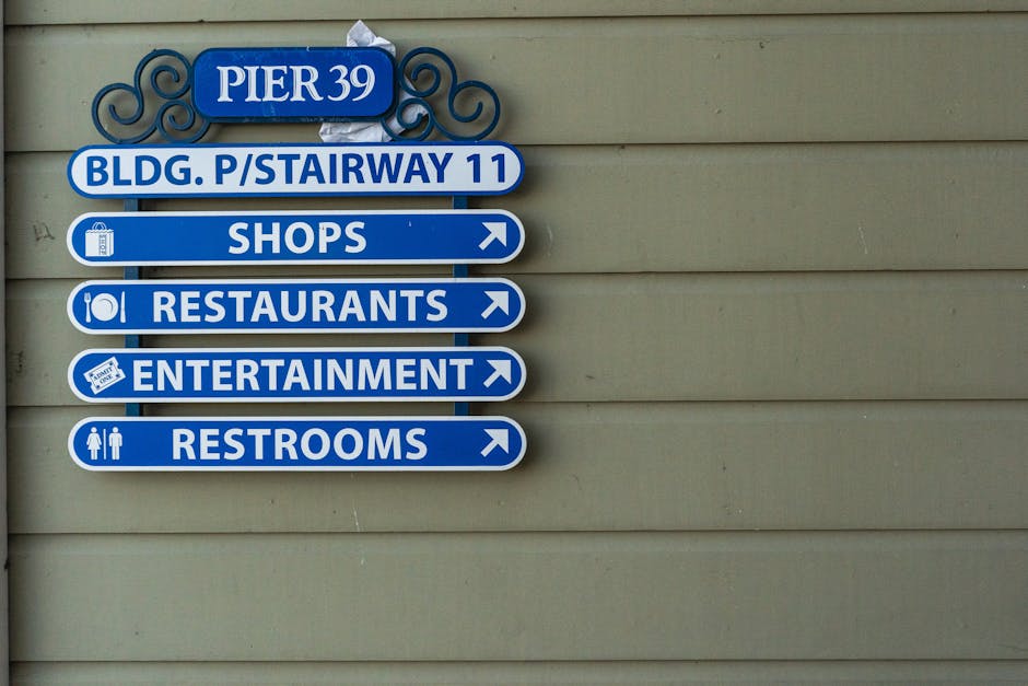 Blue directional sign at Pier 39 with options for shops, restaurants, entertainment, and restrooms.