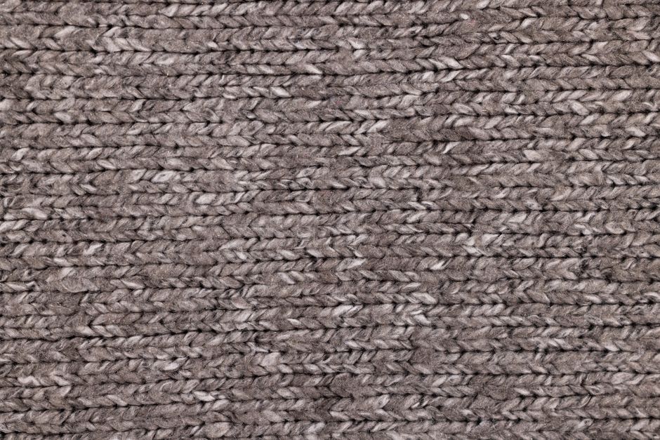 Detailed macro shot of textured brown knitted textile, ideal for fashion and fabric design.